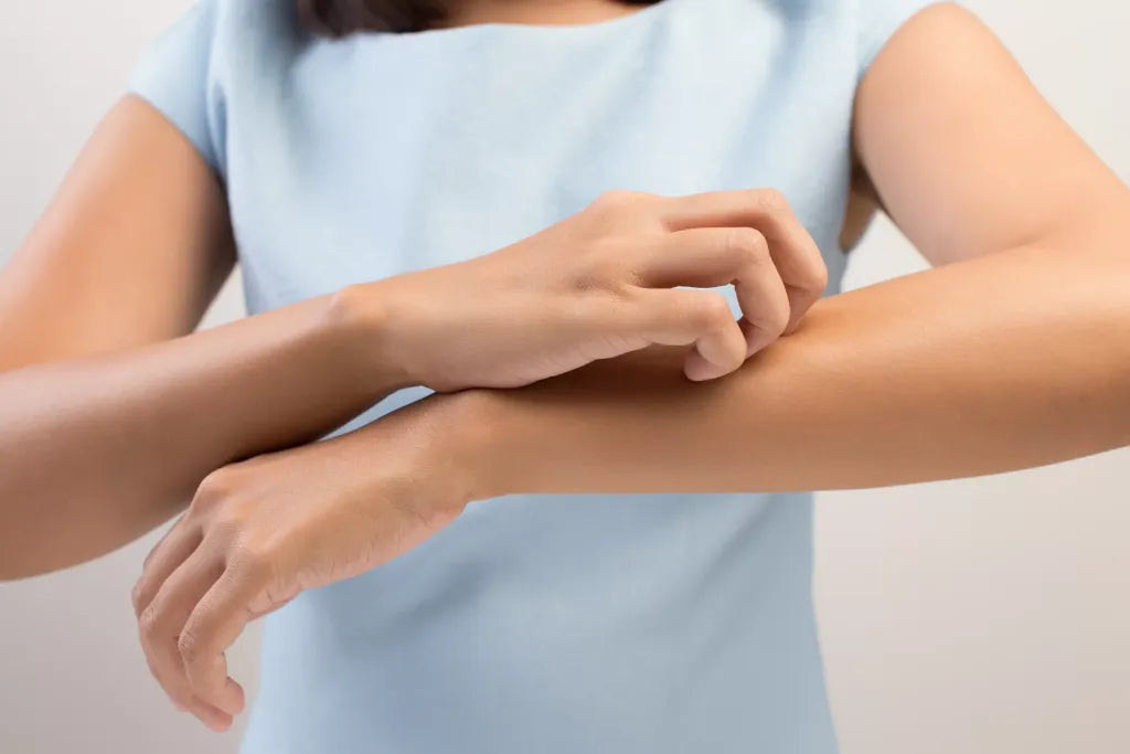 Person scratching an itchy forearm, a common skin complaint with diabetes