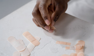 Hand picking an adhesive bandage from a table