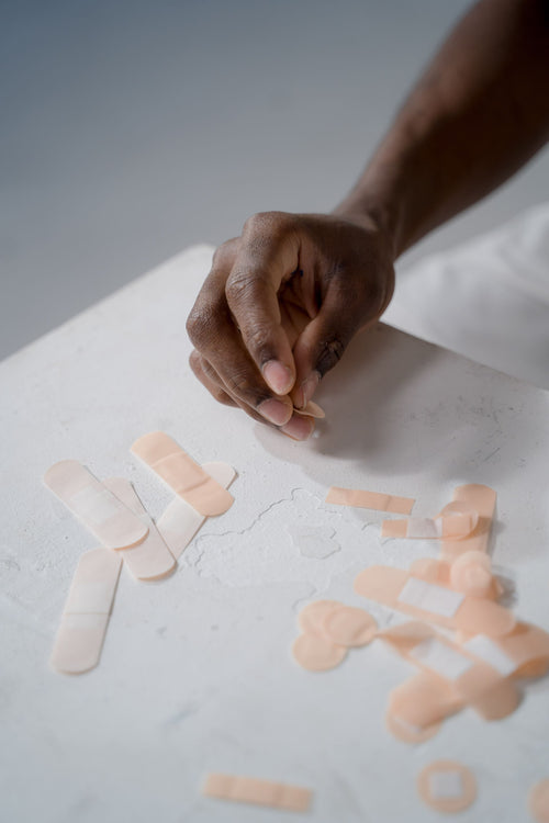Hand picking an adhesive bandage from a table